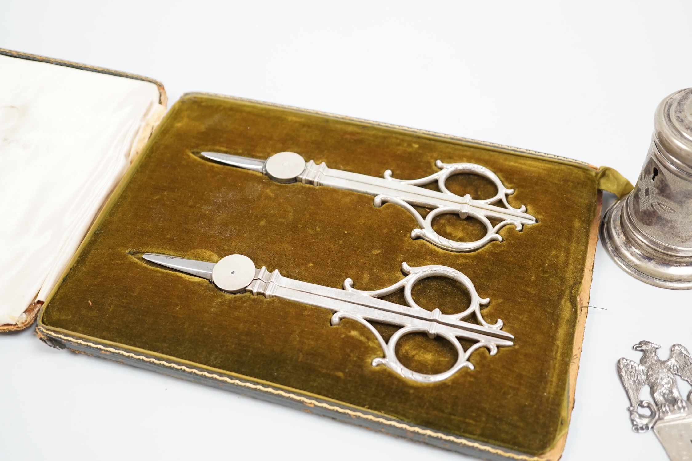 Judaica - a cased pair of scissors, a Tzedakah box, a Victorian silver circumcision guard, London 1888 and a similar plated example